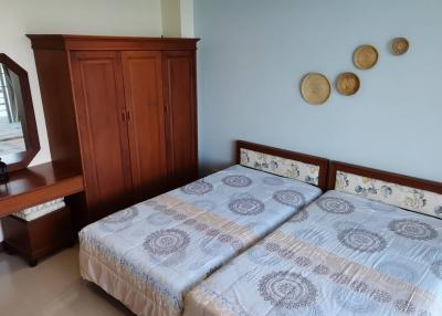 Bright and airy bedroom with double bed, wooden wardrobe, and balcony access