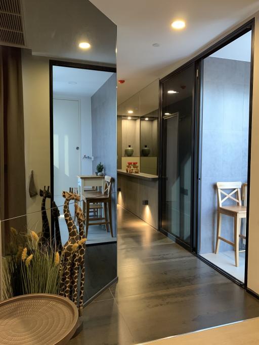 Modern interior design of a hallway with reflective surfaces and glass doors