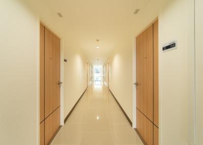 Bright and modern corridor with polished tiles and wooden doors