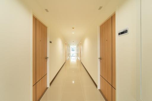 Bright and modern corridor with polished tiles and wooden doors