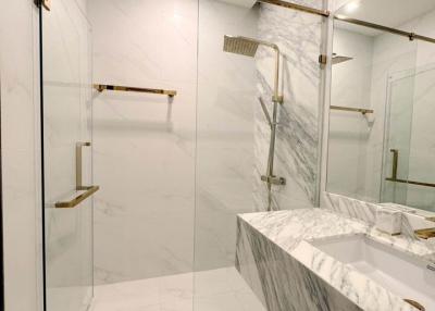 Modern bathroom with marble finishing and glass shower enclosure