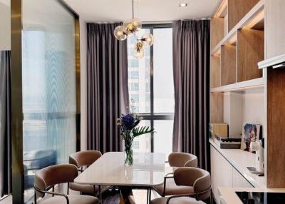 Modern dining area with stylish table and chairs, large window, and elegant lighting fixtures
