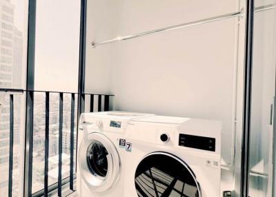 Modern appliances in a well-lit laundry room with city view