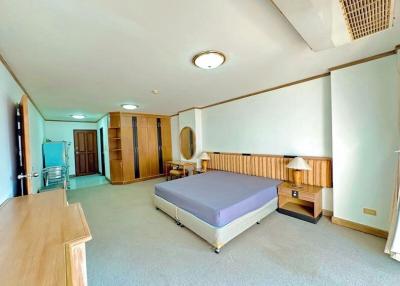 Spacious bedroom with wooden furnishings and large windows