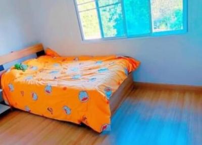 Brightly lit bedroom with blue walls and wooden floor