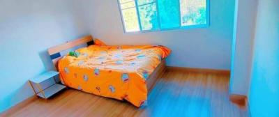 Brightly lit bedroom with blue walls and wooden floor