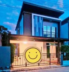 Modern two-story house with exterior lighting at dusk