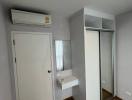 Compact bedroom with built-in wardrobe and air conditioning unit