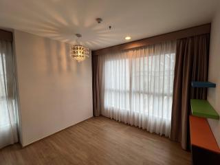 Spacious living room with large curtains and modern chandelier