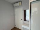 Compact bedroom with air conditioning and wooden flooring