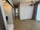 Interior view of a corridor leading to rooms with wooden flooring and a chandelier