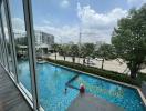 Expansive outdoor view showcasing a swimming pool and urban background from within the property