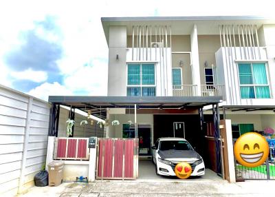 Modern two-story house facade with a car parked under the carport
