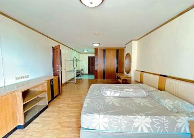 Spacious bedroom with wooden furniture and integrated kitchenette