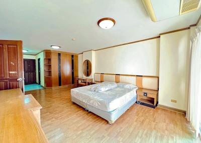 Spacious bedroom with wooden flooring and contemporary furniture