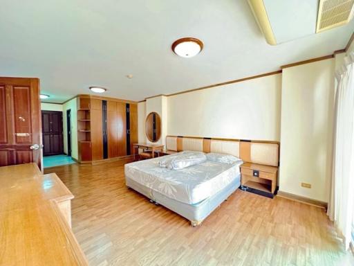 Spacious bedroom with wooden flooring and contemporary furniture