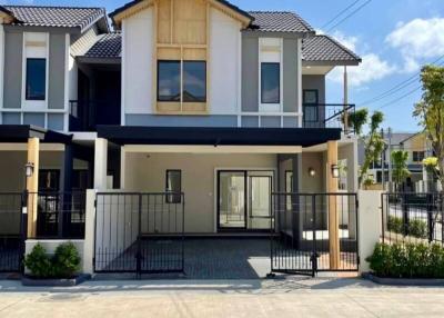 Modern two-story house with balcony and garage under a blue sky