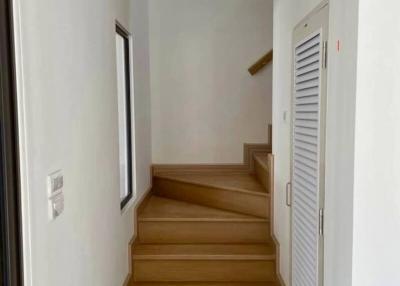 Bright hallway with wooden stairs and white doors