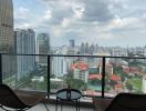 High-rise balcony overlooking a cityscape with outdoor seating