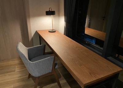 Modern minimalist workspace with wooden desk and grey chair