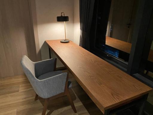 Modern minimalist workspace with wooden desk and grey chair