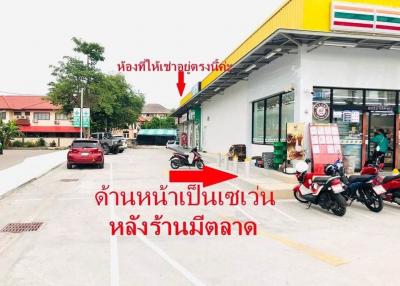 Convenience store front with parking space and vehicles