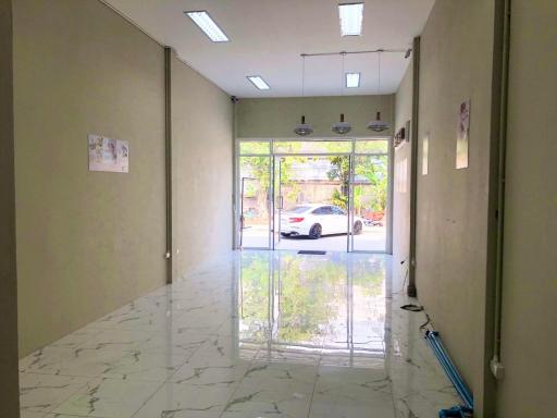 Spacious and bright commercial space with large glass front windows and shiny tile flooring