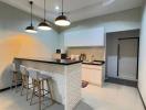 Modern kitchen with bar stools and pendant lighting