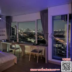 Modern bedroom with night city view through large windows