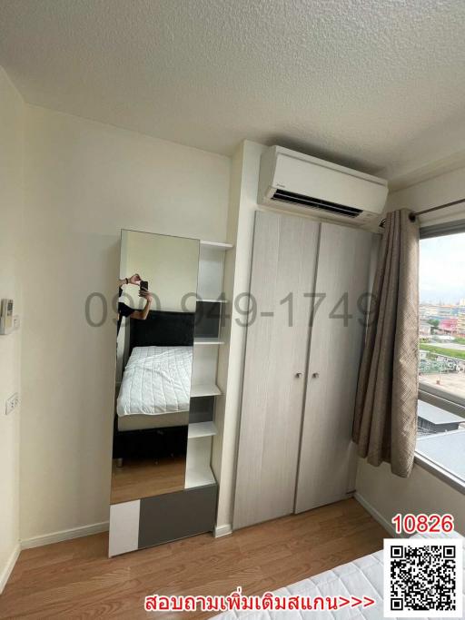 Compact bedroom with modern furnishings, including a mirrored wardrobe and an air conditioner