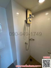 Compact bathroom with electric shower and white tiles