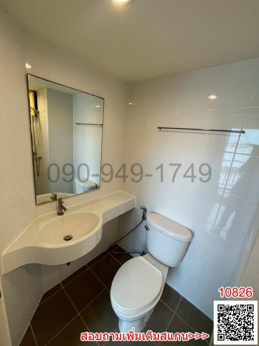 Modern bathroom with white fixtures, including sink, toilet, and mirrored medicine cabinet