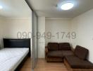 Compact bedroom with bed and sofa, mirrored closet doors