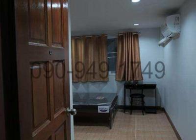 Cozy bedroom with wooden door, tiled flooring, and air conditioning