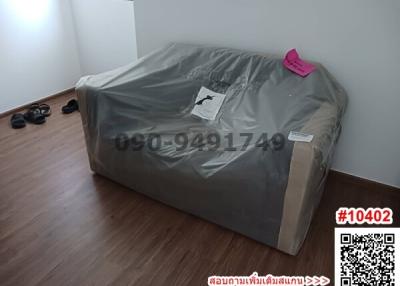 New bed with protective covering in a clean, uncluttered bedroom