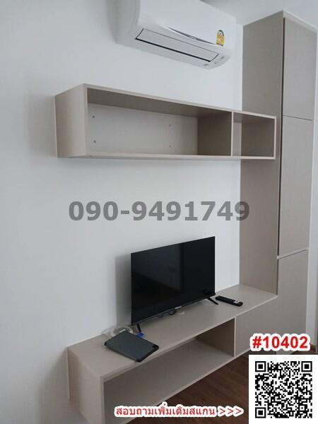 Modern minimalist living room with wall-mounted shelves, television, and air-conditioning unit