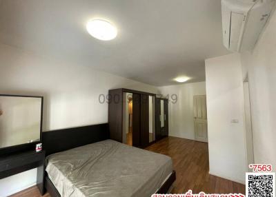 Spacious bedroom with large bed, built-in closet, and air conditioning unit
