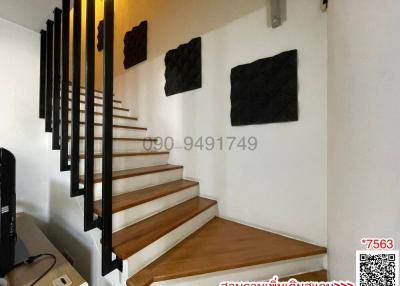 Modern wooden staircase with white walls and decorative elements