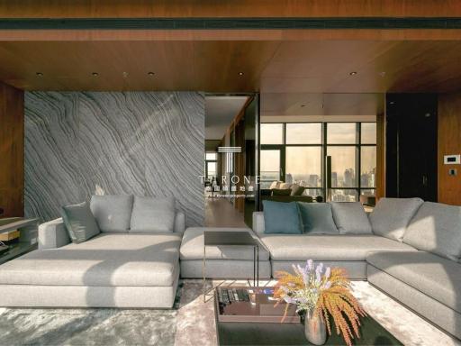 Modern living room with large sofa, marble walls and city views