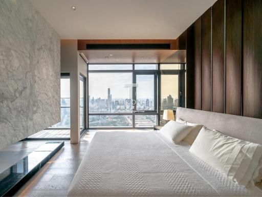 Modern bedroom with large bed and expansive city view