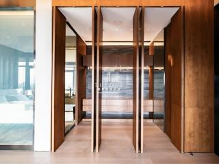 Modern office building lobby with glass doors and wood paneling