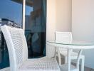 Cozy balcony with white wicker furniture and urban view