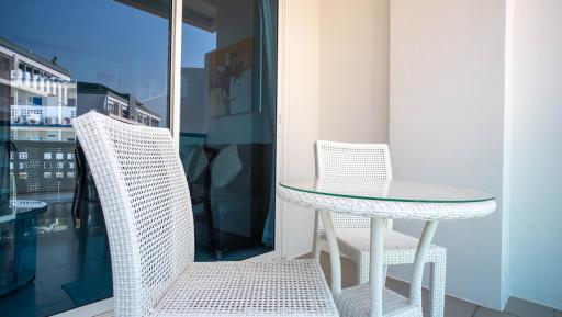 Cozy balcony with white wicker furniture and urban view