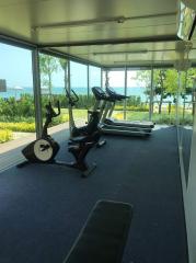 Gym area with exercise equipment and view of greenery