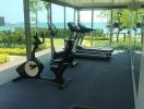 Gym area with exercise equipment and view of greenery