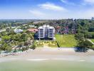 Aerial view of a waterfront apartment complex with surrounding greenery