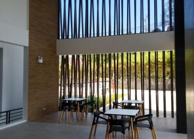 Modern building entrance with high ceiling and outdoor seating area