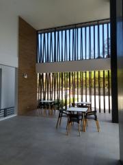 Modern building entrance with high ceiling and outdoor seating area
