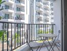 Compact balcony with outdoor seating overlooking residential complex