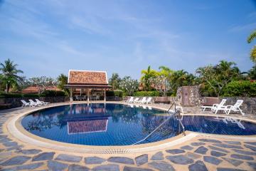 Spacious outdoor swimming pool with sun loungers and poolside cabana